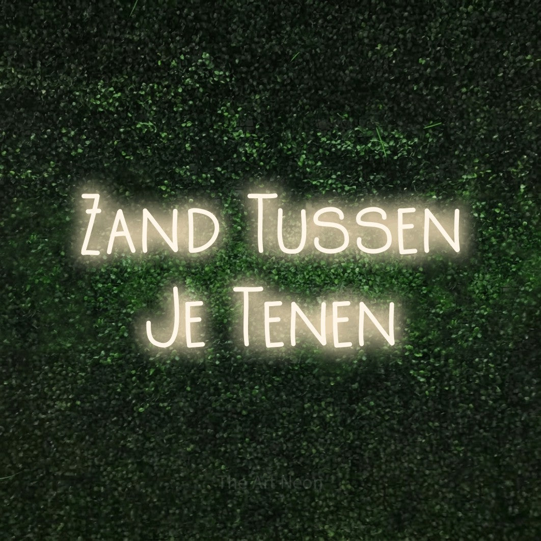 LED neon sign reading “Zand Tussen Je Tenen”, arranged in 2 lines.