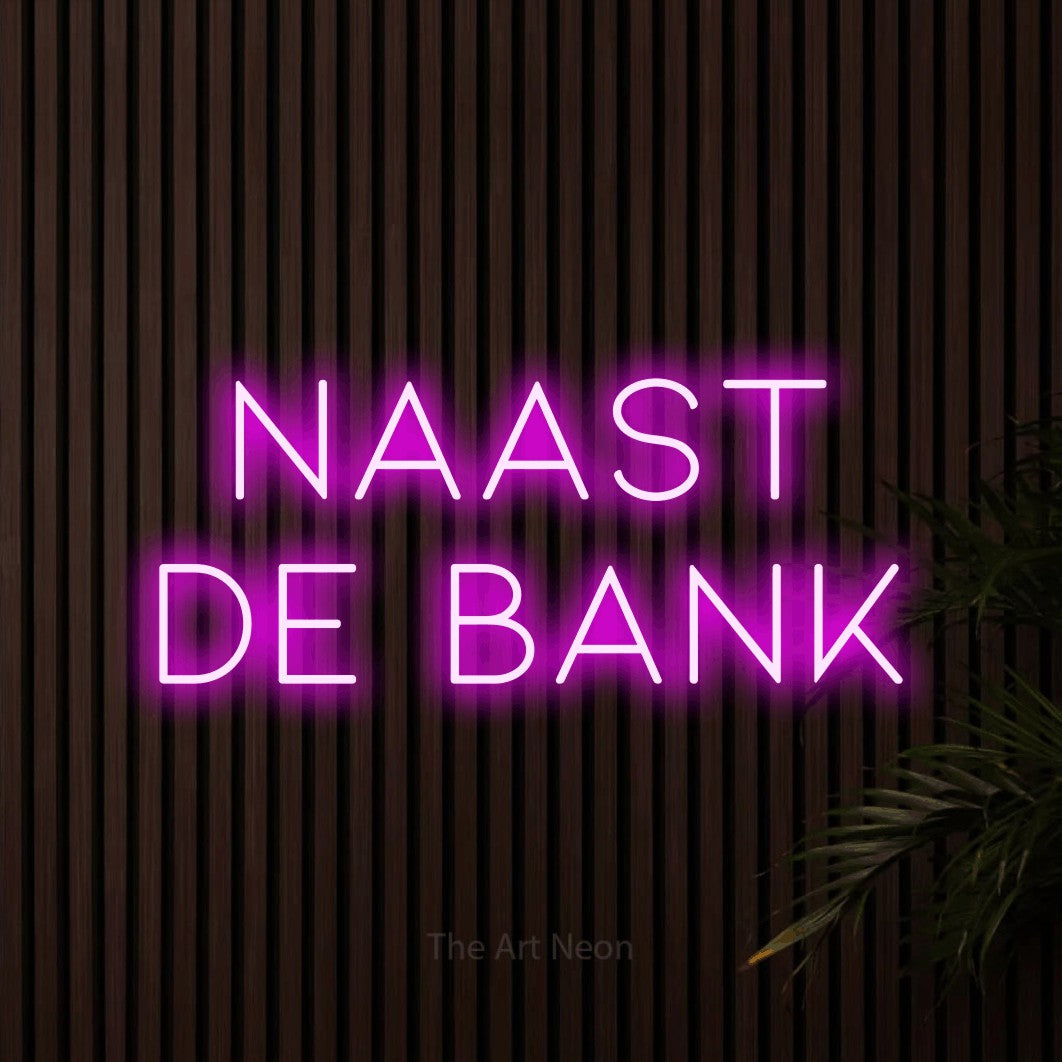 LED neon sign reading “naast de bank”, arranged in 2 lines.