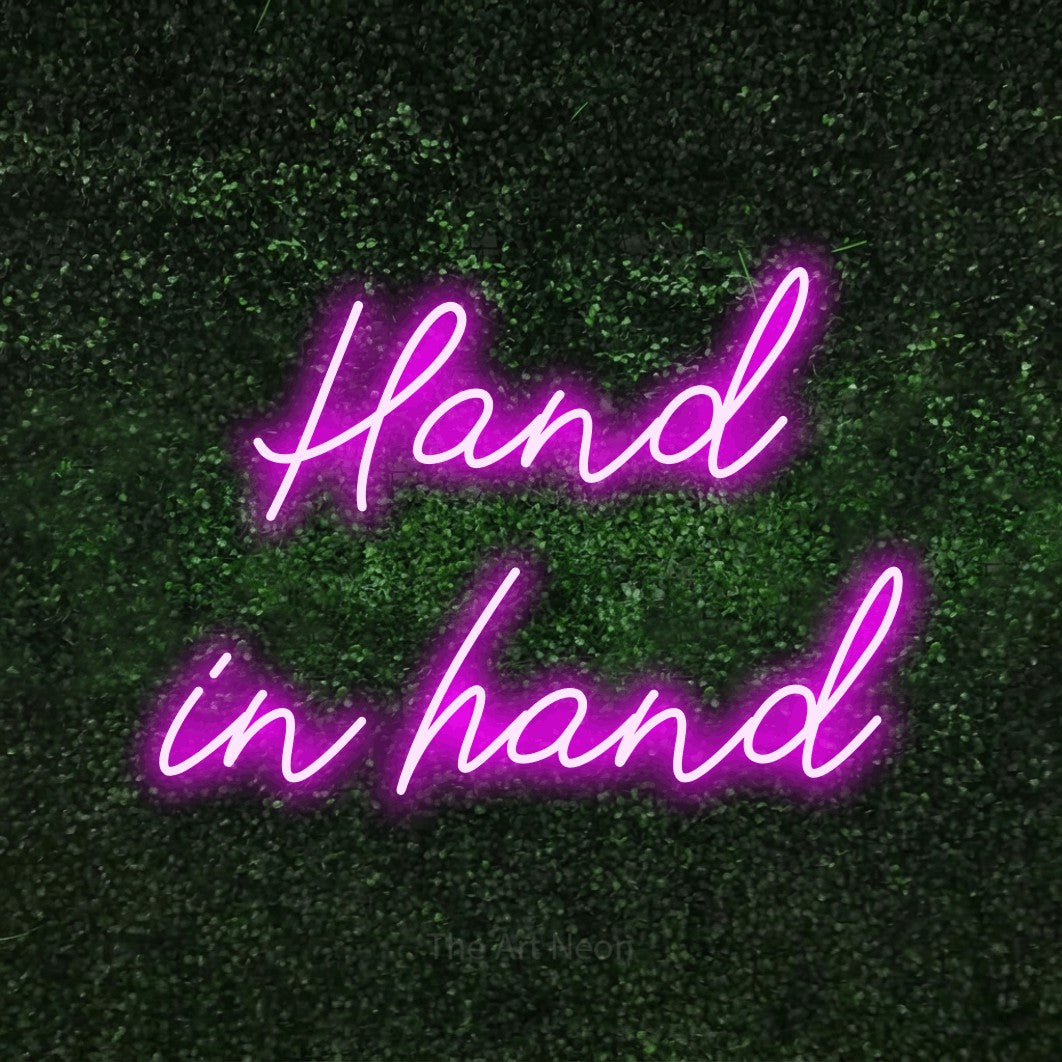 LED neon sign reading “Hand in hand”, arranged in 2 lines.