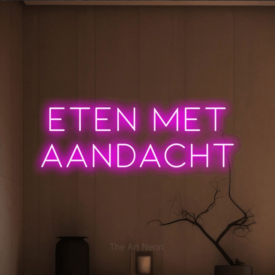 LED neon sign reading “ETEN MET AANDACHT”, arranged in 2 lines.