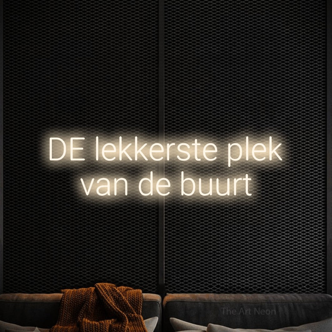LED neon sign reading “DE lekkerste plek van de buurt”, arranged in 2 lines.