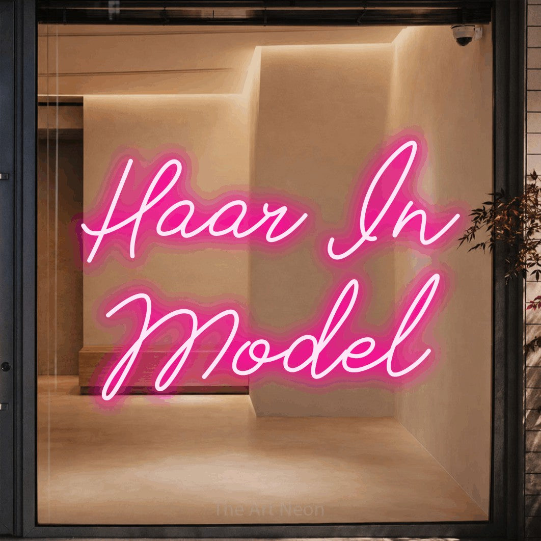 LED neon sign reading “Haar In Model”, arranged in 2 lines.