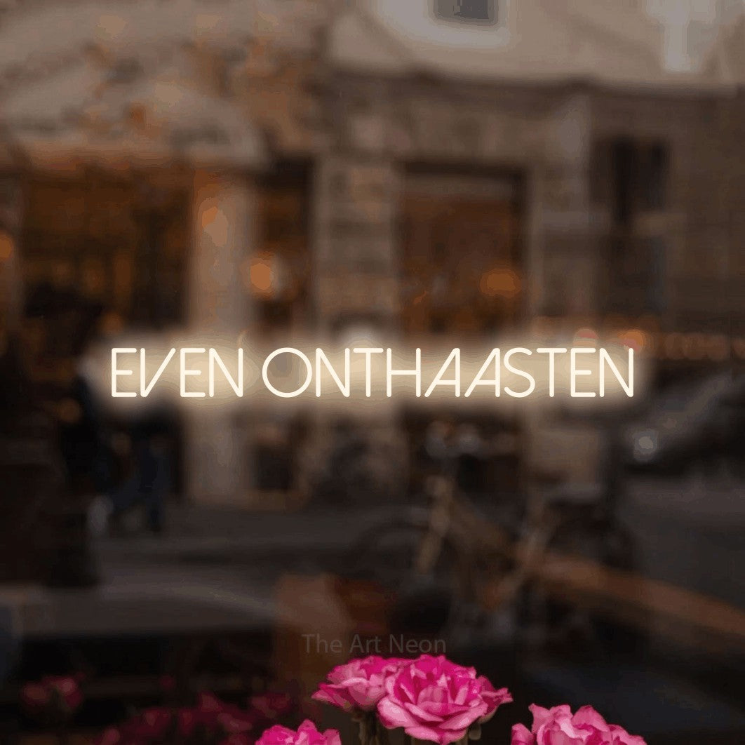 LED neon sign reading “even onthaasten”, arranged in a single line.
