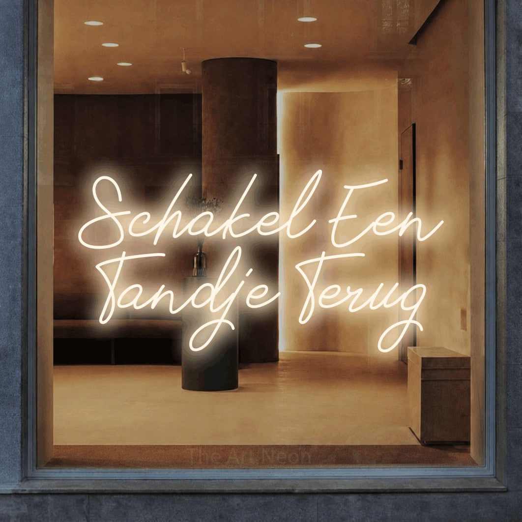 LED neon sign reading “Schakel Een Tandje Terug”, arranged in 2 lines.