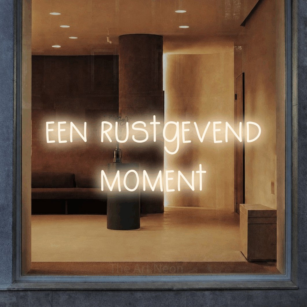 LED neon sign reading “een rustgevend moment”, arranged in 2 lines.