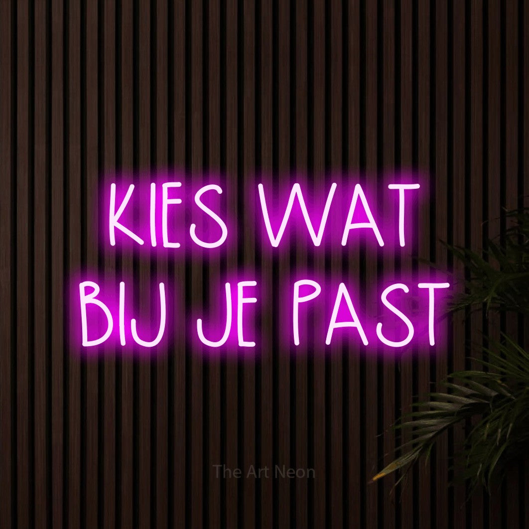 LED neon sign reading “KIES WAT BIJ JE PAST”, arranged in 2 lines.
