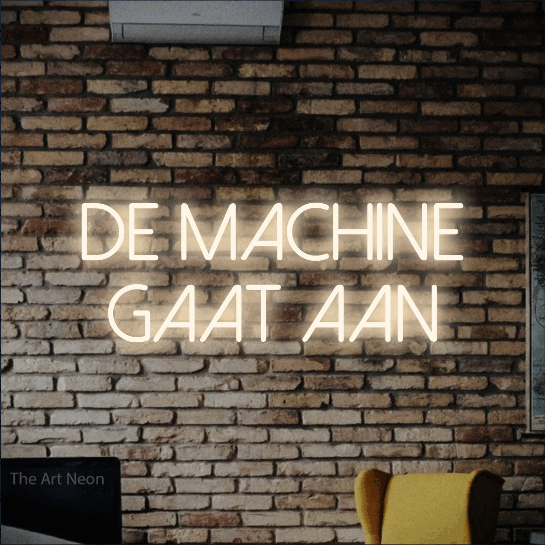 LED neon sign reading “DE machine gaat aan”, arranged in 2 lines.