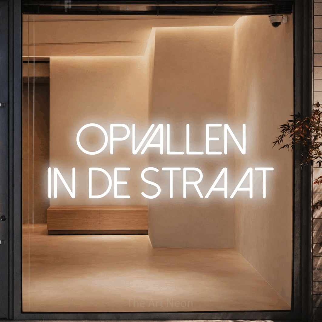 LED neon sign reading “opvallen in de straat”, arranged in 2 lines.