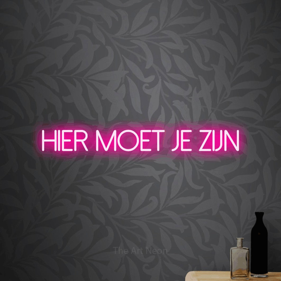 LED neon sign reading “hier moet je zijn”, arranged in a single line.