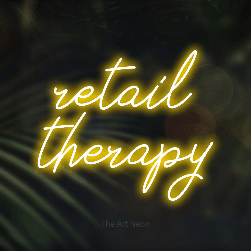 LED neon sign reading “retail therapy”, arranged in 2 lines.