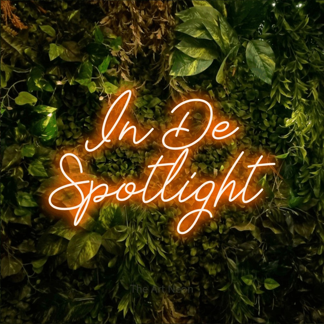 LED neon sign reading “In De Spotlight”, arranged in 2 lines.