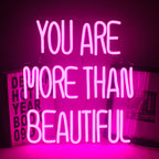 Op de afbeelding staat een levendig led-neonbord met de tekst: "You Are More Than Beautiful".