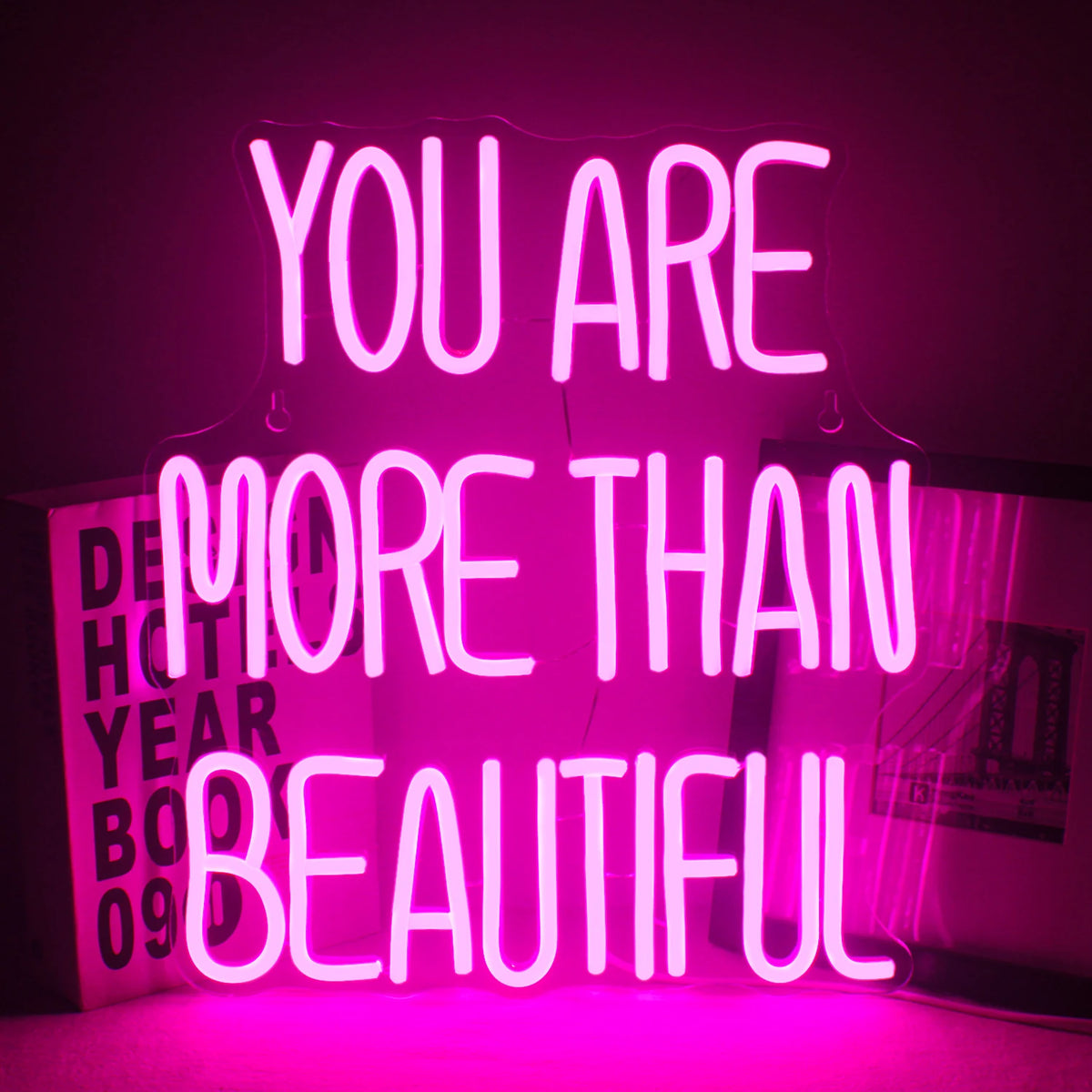 Op de afbeelding staat een levendig led-neonbord met de tekst: "You Are More Than Beautiful".