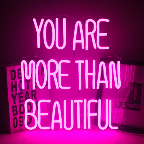 Op de afbeelding staat een levendig led-neonbord met de tekst: "You Are More Than Beautiful".