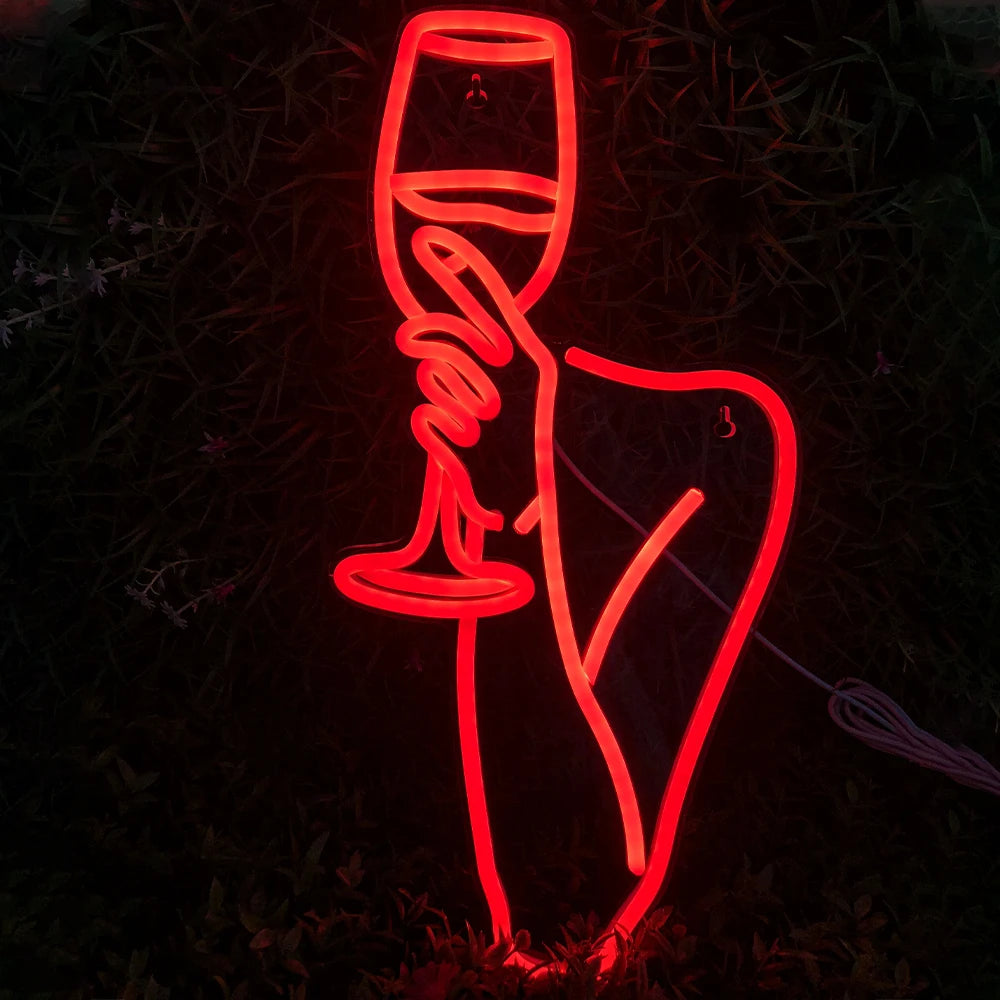 De afbeelding toont een levendig led-neonbord met de omtrek van een vrouw die een wijnglas vasthoudt.