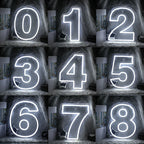 The image displays a colorful LED neon sign in the shape of a digital number "7".
