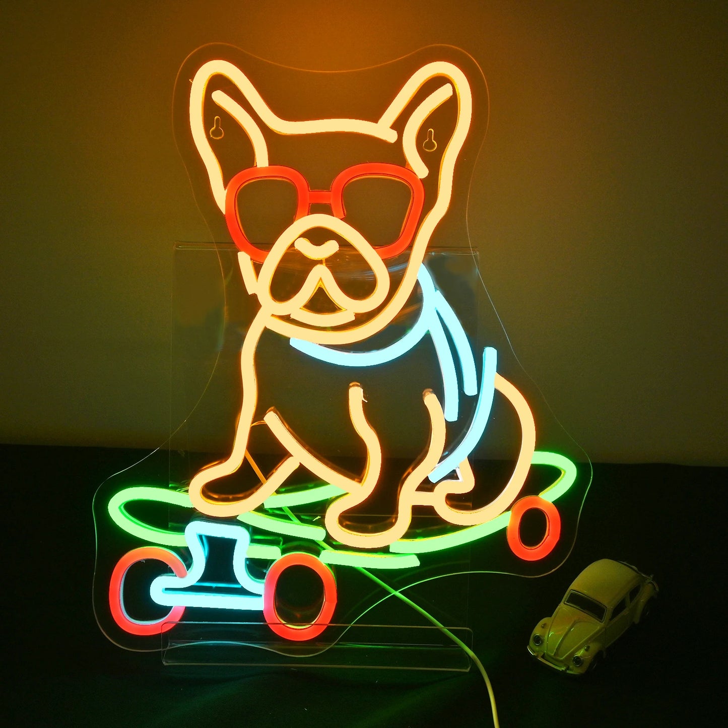 The image displays a vibrant LED neon sign depicting a playful cartoon dog skateboarding.