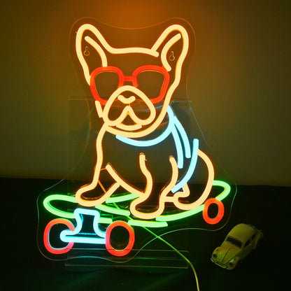 The image displays a vibrant LED neon sign depicting a playful cartoon dog skateboarding.