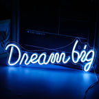 Op de afbeelding staat een levendig led-neonbord met de tekst 'Dream Big'.