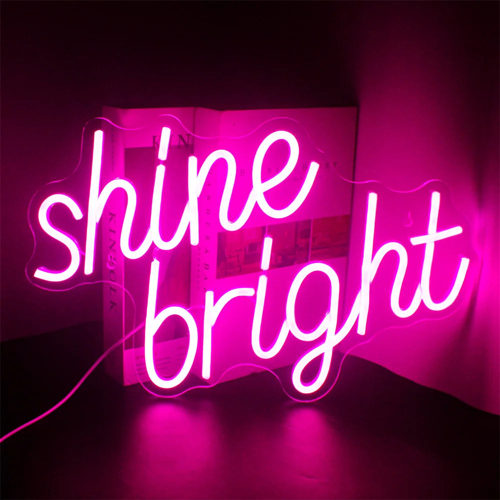 De afbeelding toont een levendig en stijlvol LED-neonbord met de tekst "Shine Bright" in elegant, cursief handschrift.
