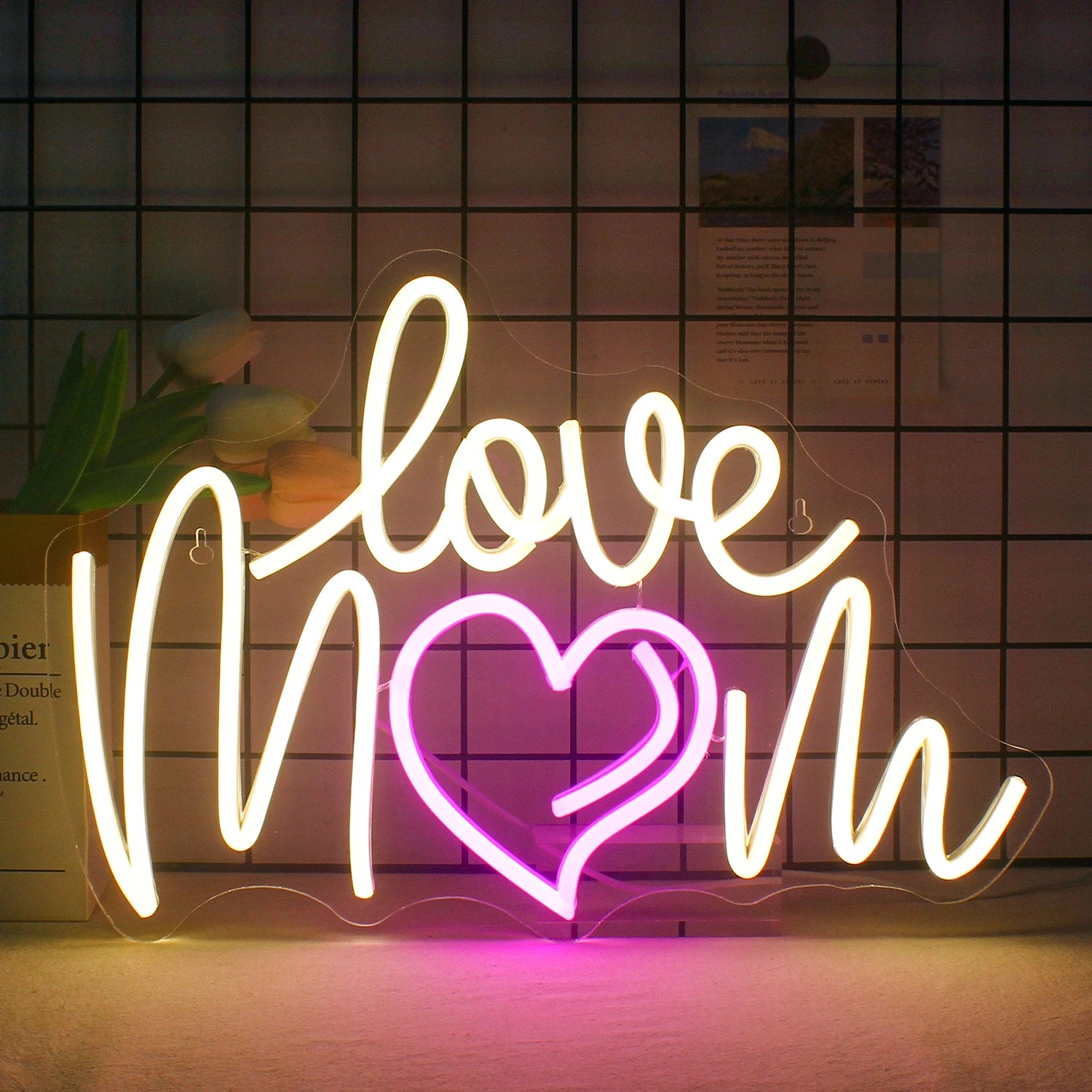 The image displays a vibrant LED neon sign featuring the phrase "Love Mom" in cursive.