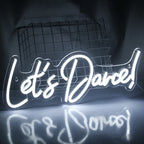 A brightly lit "Let's Dance" LED neon sign in vibrant pink and blue colors.