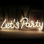 The image features a vibrant, handmade LED neon sign that reads "Let's Party" in playful, cursive script.