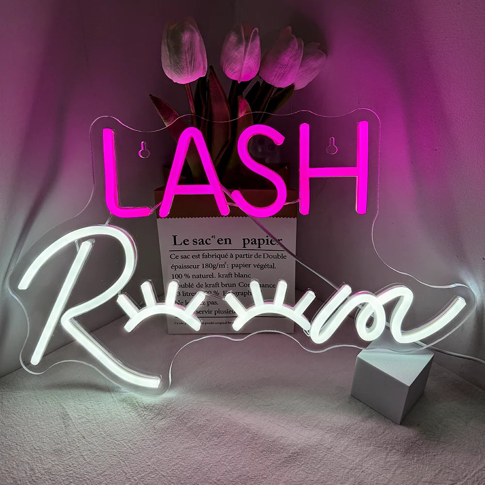 Op de afbeelding staat een opvallend LED-neonbord met de tekst "Lash Room" in een stijlvol, cursief lettertype.