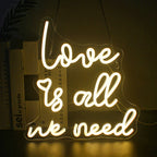 Op de afbeelding staat een opvallend led-neonbord met de tekst "Love is all we need" in een vloeiend, cursief lettertype.