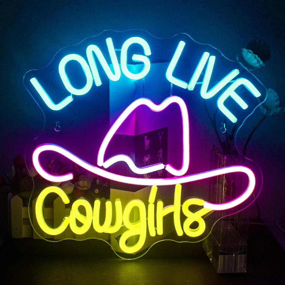 A vibrant LED neon sign displaying the words "Long Live Cowgirls" in a bold, cursive script.