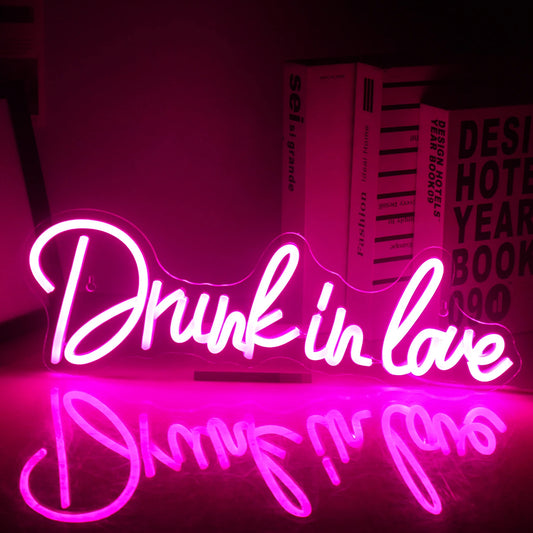 A vibrant, handmade LED neon sign displaying the phrase "Drunk In Love" in stylish, cursive lettering.