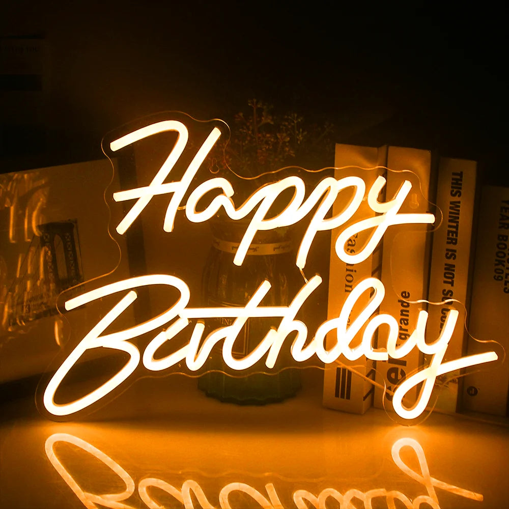 Een levendig "Happy Birthday" LED-neonbord licht op tegen een donkere achtergrond.