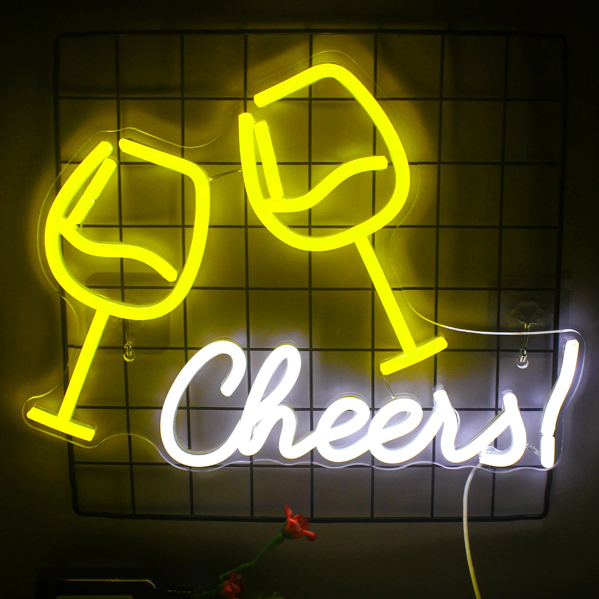 Een opvallend LED-neonbord met de tekst "Cheers" in een speels, cursief lettertype is tegen een bakstenen muur bevestigd.