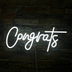 The image features a handmade LED neon sign displaying the word "Congrats" in a stylish, flowing script.