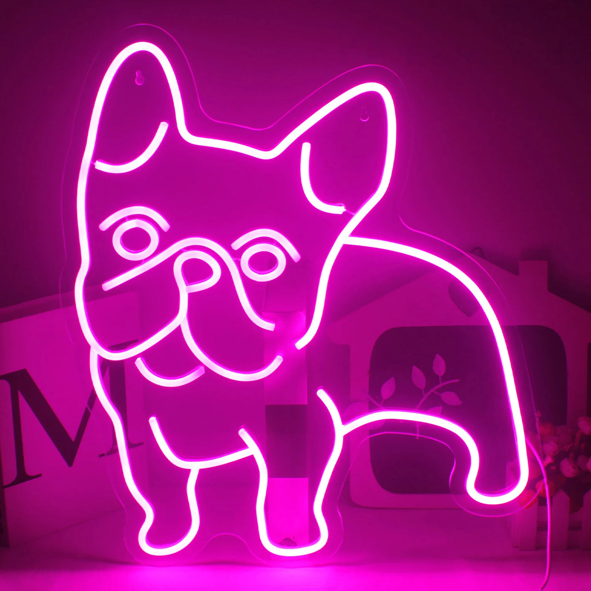 De afbeelding toont een opvallend roze LED-neonbord in de vorm van een hond.