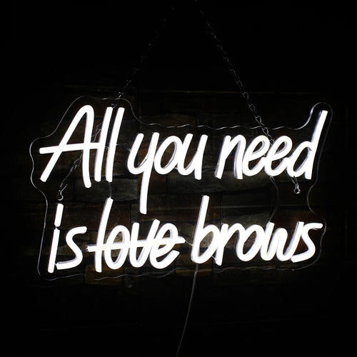 Op de afbeelding is een levendig LED-neonbord te zien met de tekst "All you need is brows".