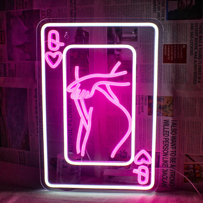 The image features an LED neon sign depicting a stylized representation of a woman composed of playing card elements.