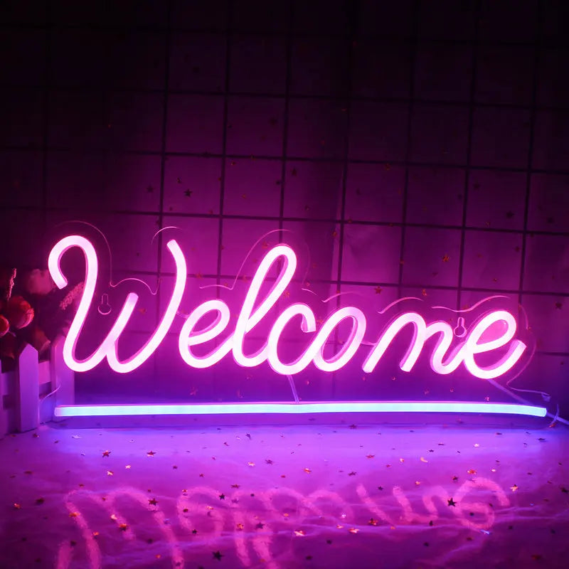 Een levendig "Welkom" LED-neonbord tegen een effen witte muur.