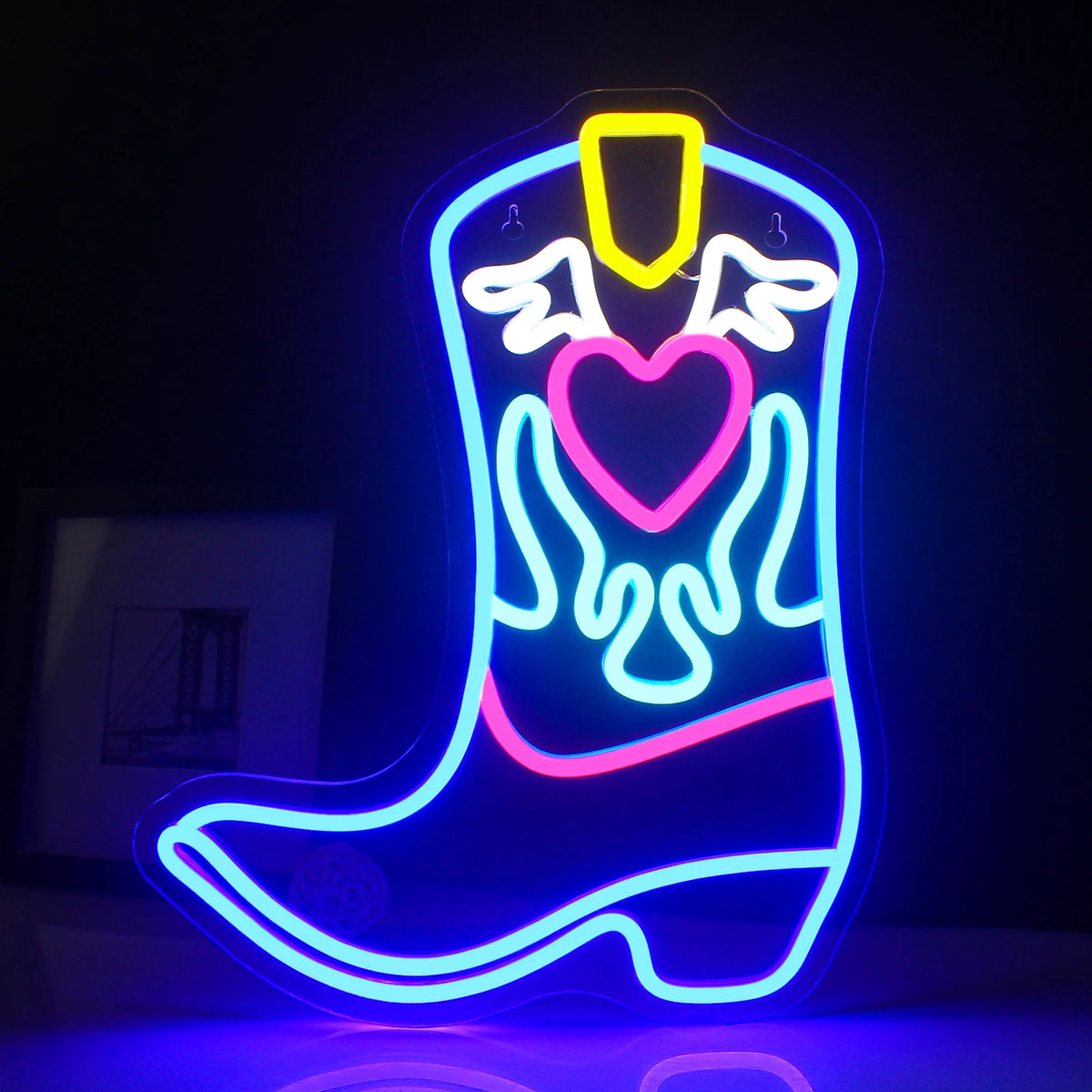 Een levendig LED-neonbord in de vorm van een cowboylaars, dat fel oplicht in warme kleuren.