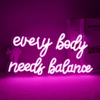 Op de afbeelding is een levendig LED-neonbord te zien met de tekst "Every Body Needs Balance".