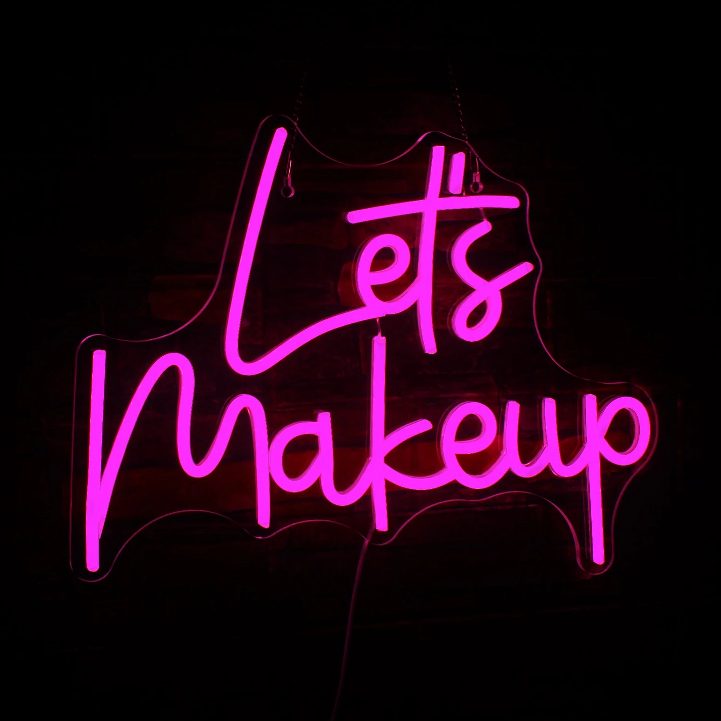 A stylish LED neon sign displaying the phrase "Let's Makeup" in vibrant pink cursive letters.