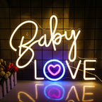 Een opvallend roze neonbord toont de woorden "Baby Love" in een speels, cursief lettertype.