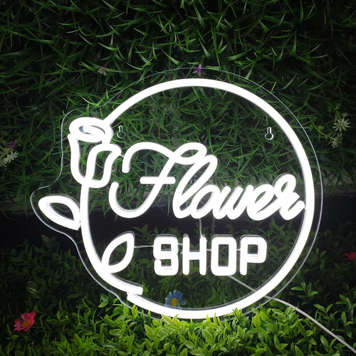 Op de afbeelding staat een opvallend LED-neonbord met de tekst 'Flower Shop' in sierlijke letters.