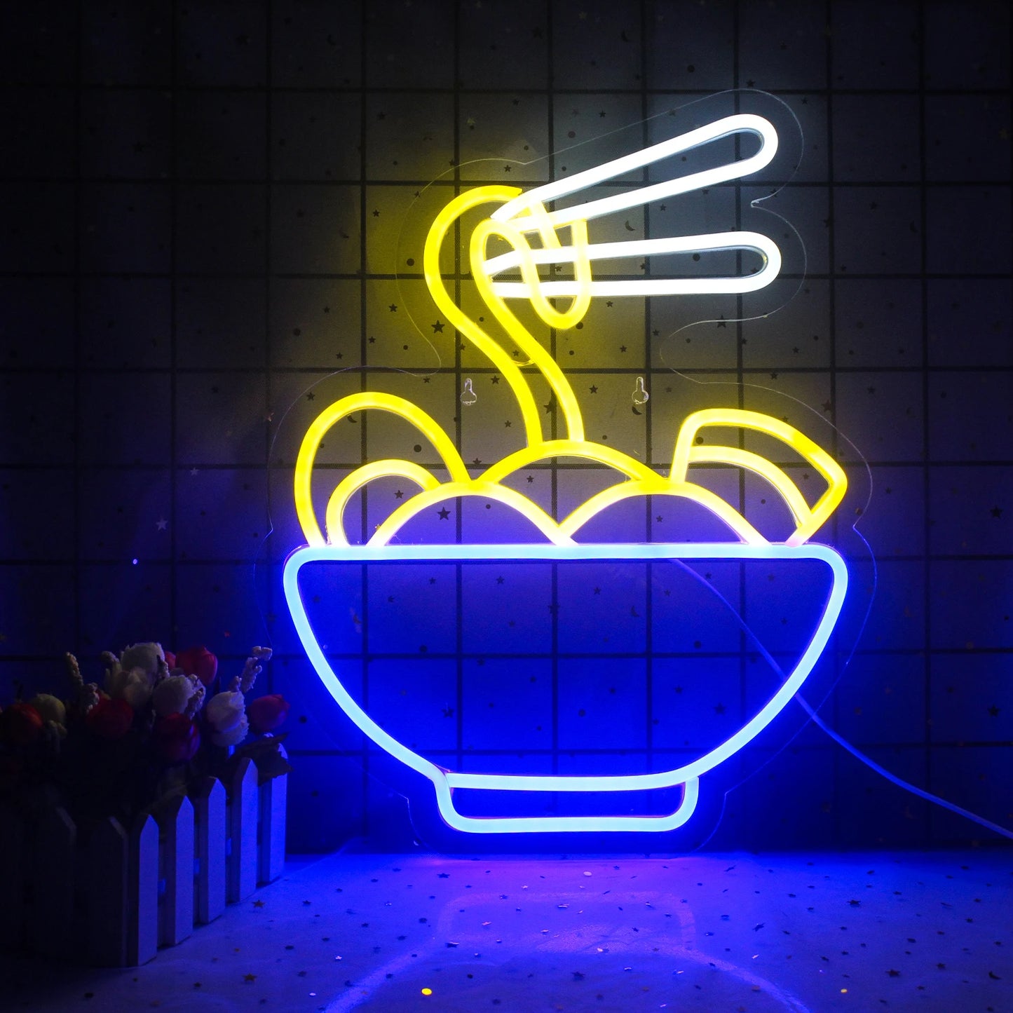 The image features a vibrant LED neon sign showcasing the word "Ramen" in bold, stylized letters.