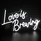 Een levendig LED-neonbord met de tekst "Love is Breaking" in opvallende, moderne typografie.