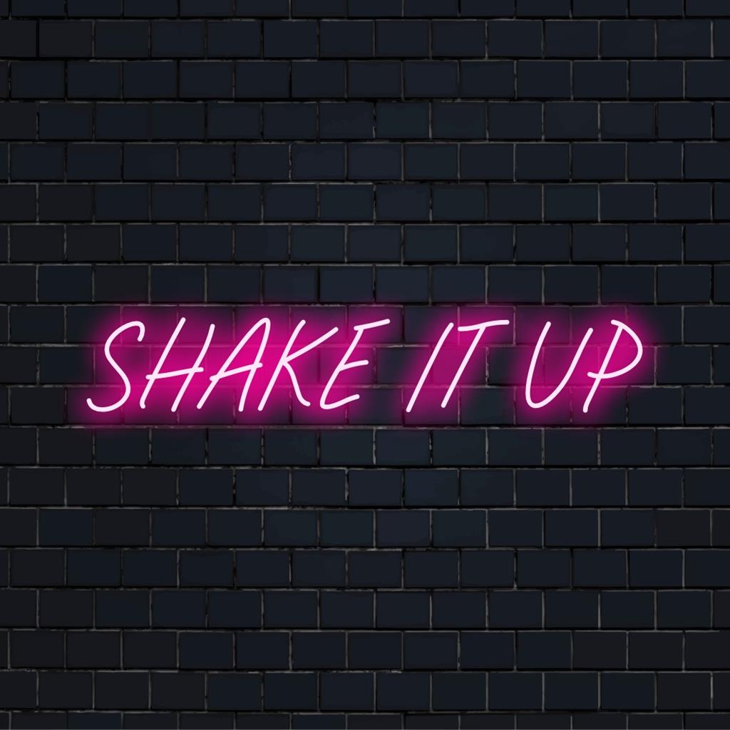 Energiek oranje en roze LED-neonbord met de tekst Shake It Up, dat levendige energie en feestvreugde uitstraalt.