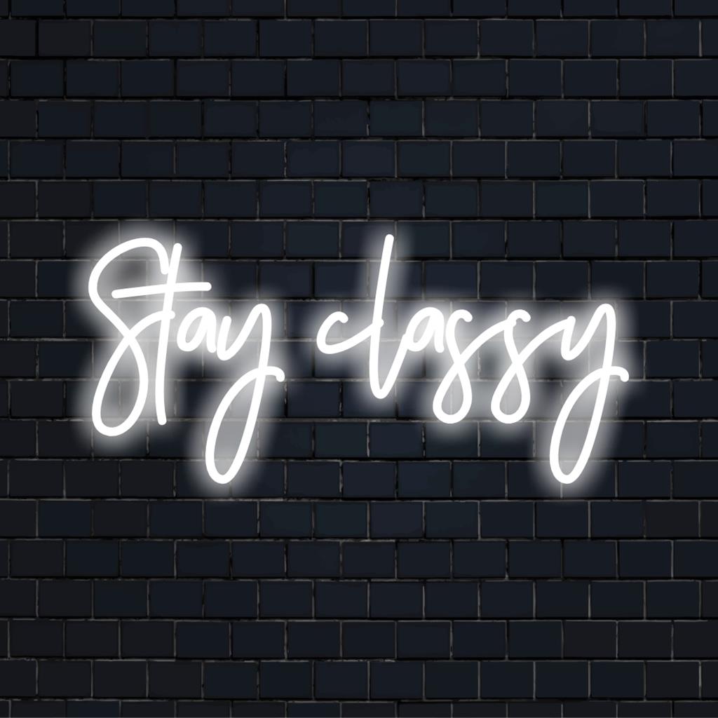 Een stijlvol, op maat gemaakt LED-neonbord met Stay Classy, ​​verlicht in levendige kleuren, perfect voor een chique wanddecoratie.