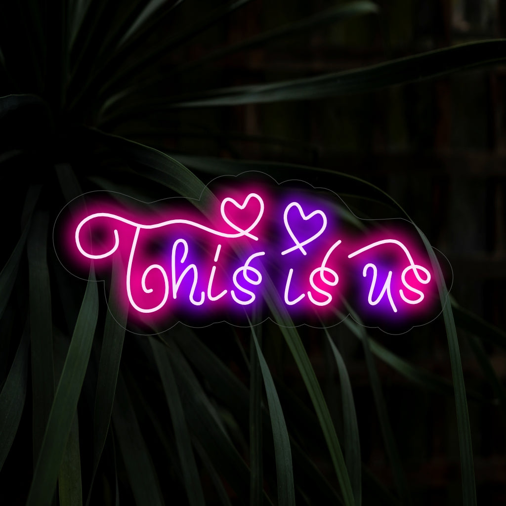 "This Is Us Neon Sign" belichaamt eenheid met zijn sentimentele boodschap en werpt een warme gloed die een sfeer van verbondenheid en saamhorigheid in uw ruimte creëert.