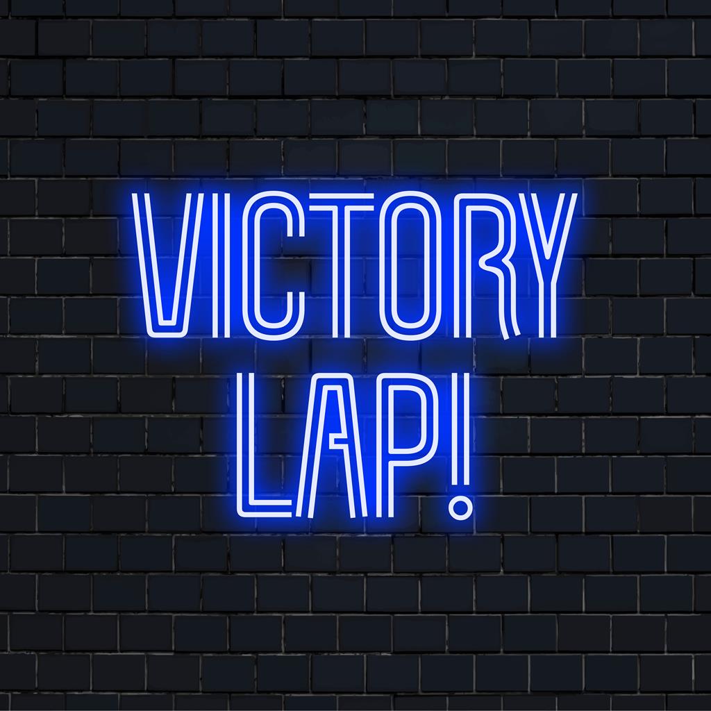 Een gepersonaliseerd neonbord met de tekst Victory Lap! in felle kleuren, verlicht elke ruimte en is perfect als gepersonaliseerde neondecoratie.