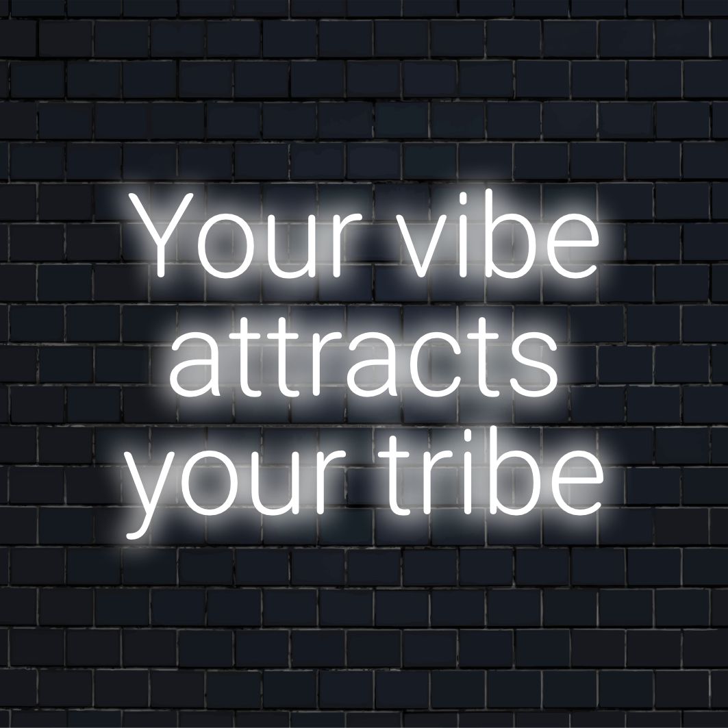 Levendig neonbord met de tekst Your Vibe Attracts Your Tribe in stijlvolle LED-letters, perfect voor wandkunst en moderne inrichting.